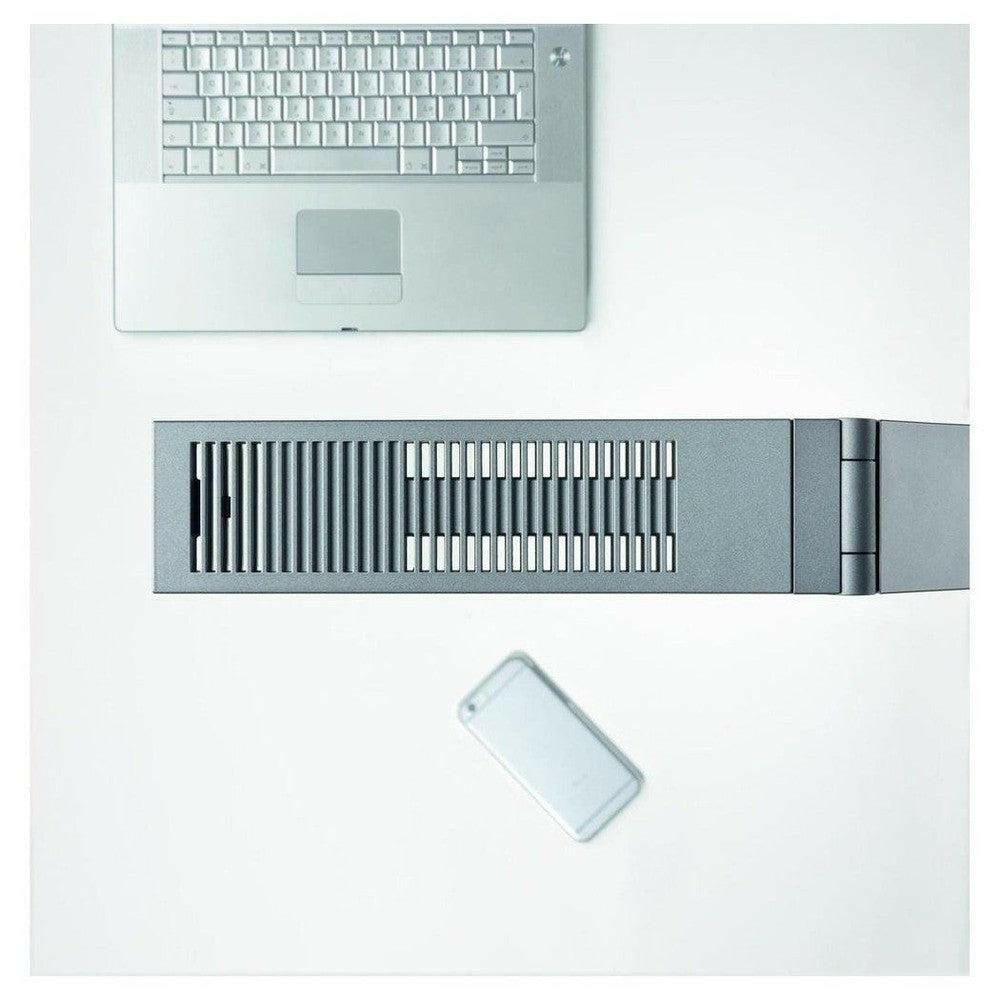 Bovenopname van grijze Luctra Linear bureaulamp met ventilatiegaten en laptop