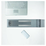 Bovenopname van grijze Luctra Linear bureaulamp met ventilatiegaten en laptop