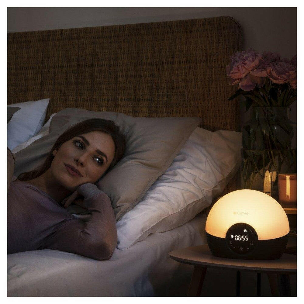 Lumie Bodyclock Glow 150 warme gloed op nachtkastje bij ontspannen gebruiker