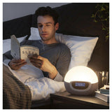 Man leest boek bij Lumie Bodyclock Shine 300 met gedempte warme verlichting