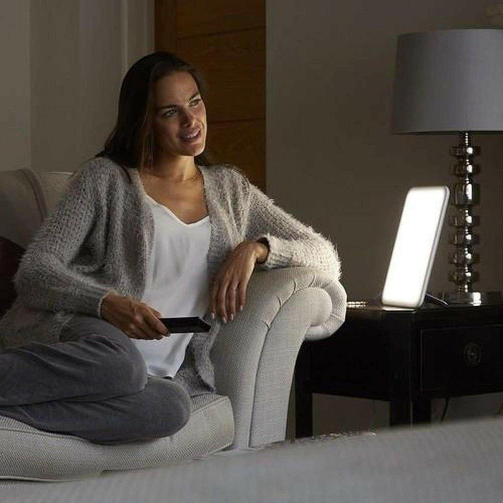 Lumie daglichtlamp op nachtkastje naast fauteuil