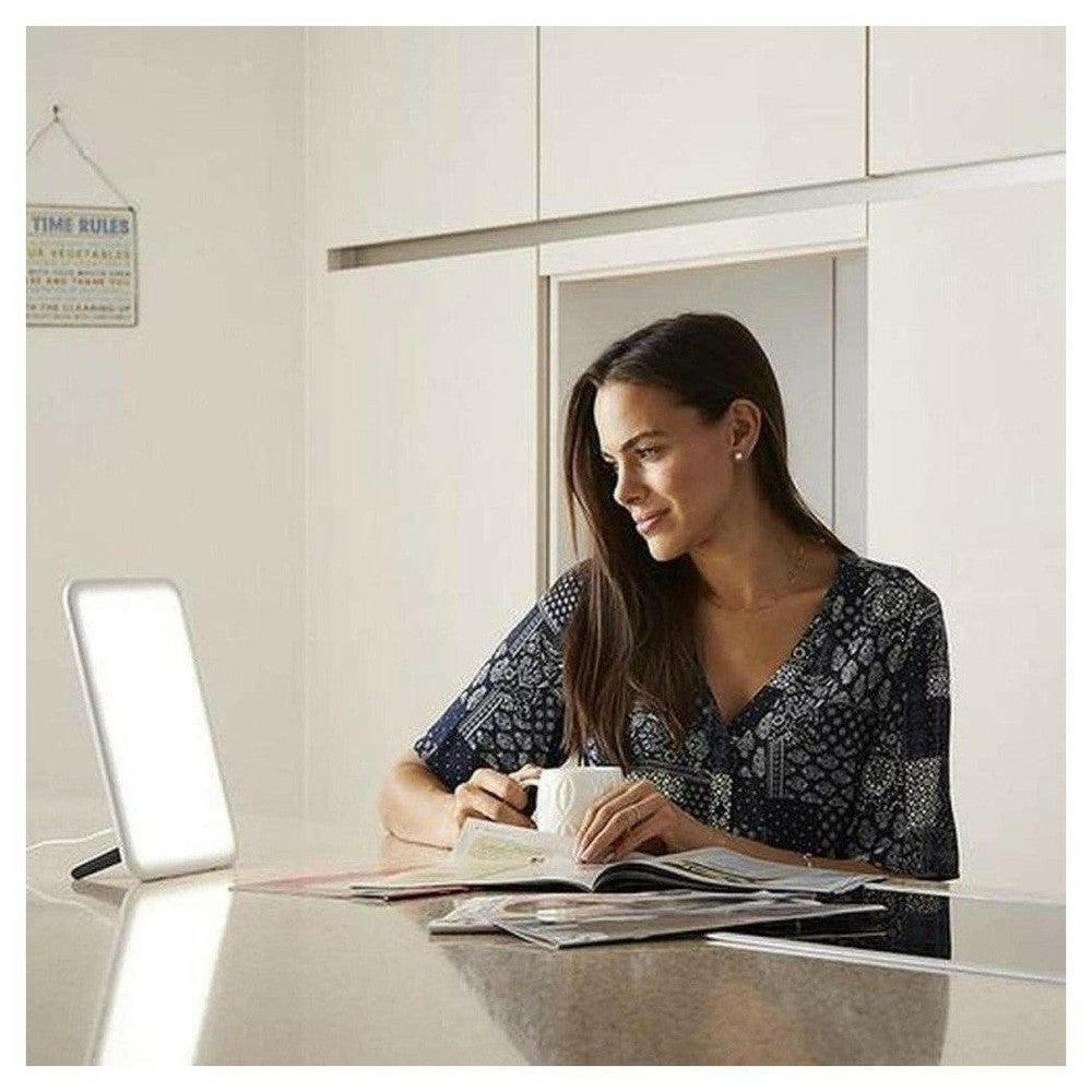 Witte Lumie Vitamin L lamp op tafel tijdens lezen en ontspanning