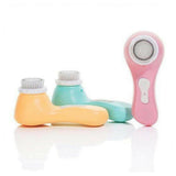 drie gekleurde Magnitone Barefaced gezichtsborstels: roze, oranje en turkoois