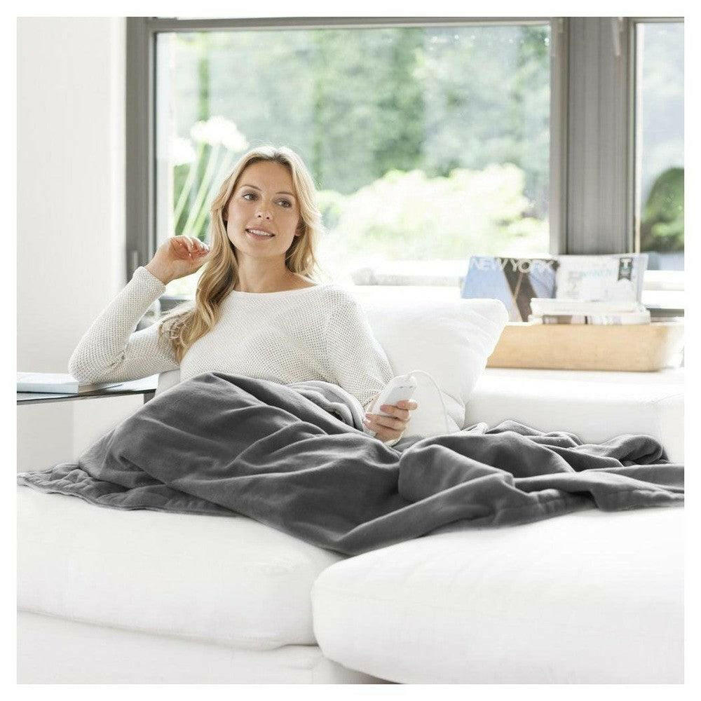 Medisana warmtedeken XXL donkergrijs vrouw op bank met afstandsbediening winter comfort