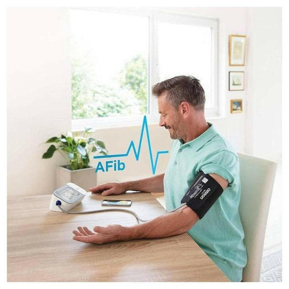 Omron M6 Comfort AFib bloeddrukmeter in gebruik met Intelli Wrap manchet voor bovenarm