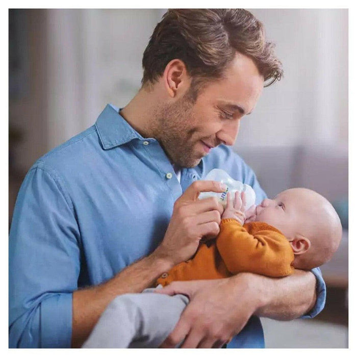 Vader voedt baby met Philips Avent fles
