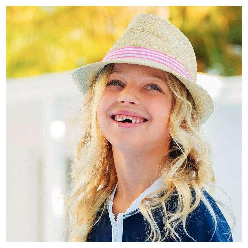 Meisje draagt lichtgekleurde Snapper Rock fedora met roze-wit lint buiten