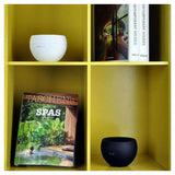 Stadler Form Jasmine aroma diffusers in wit en zwart op gele boekenkast voor woonkamer sfeer