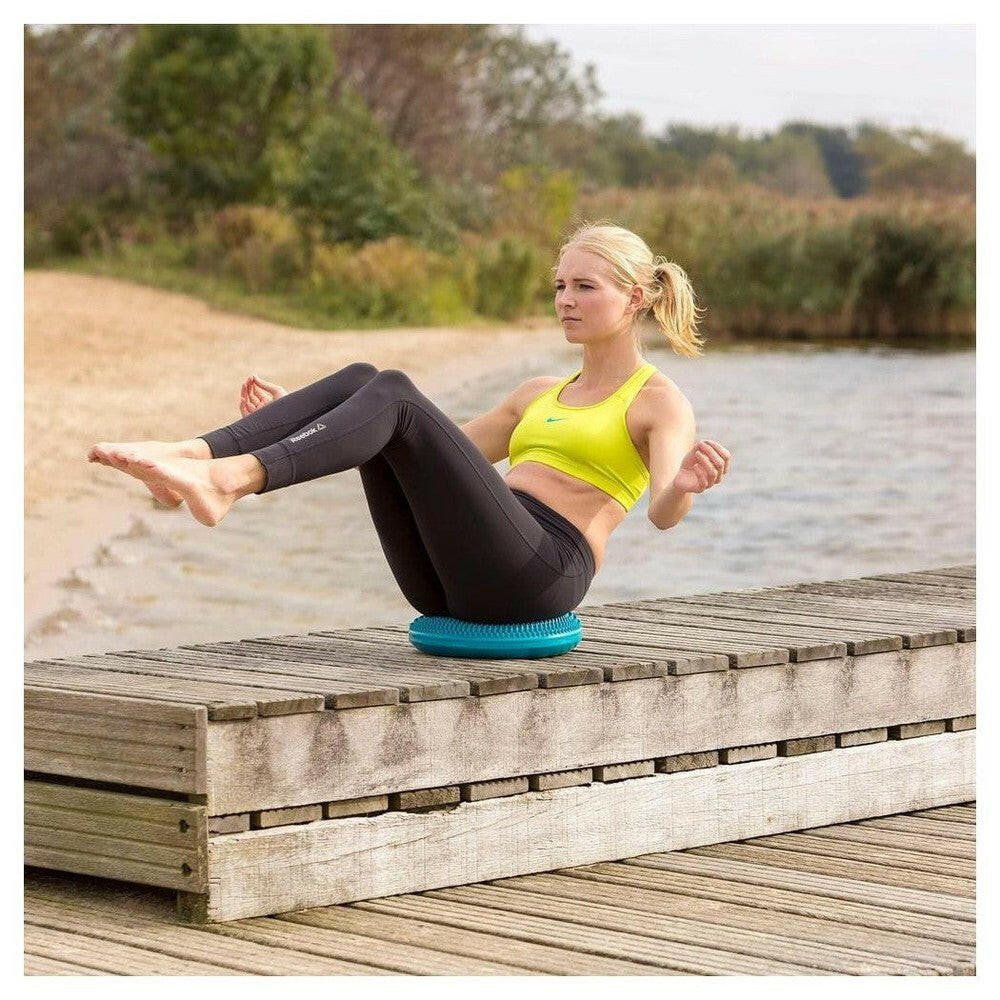 Vrouw zit op Tunturi Air Stepper Pad blauw met kegels voor zithouding