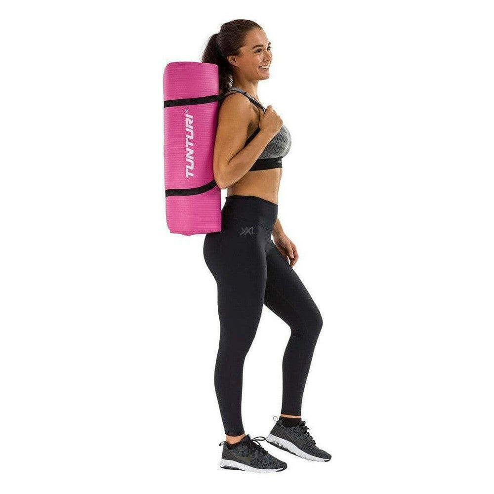 Opgerolde roze Tunturi fitnessmat NBR gedragen over schouder