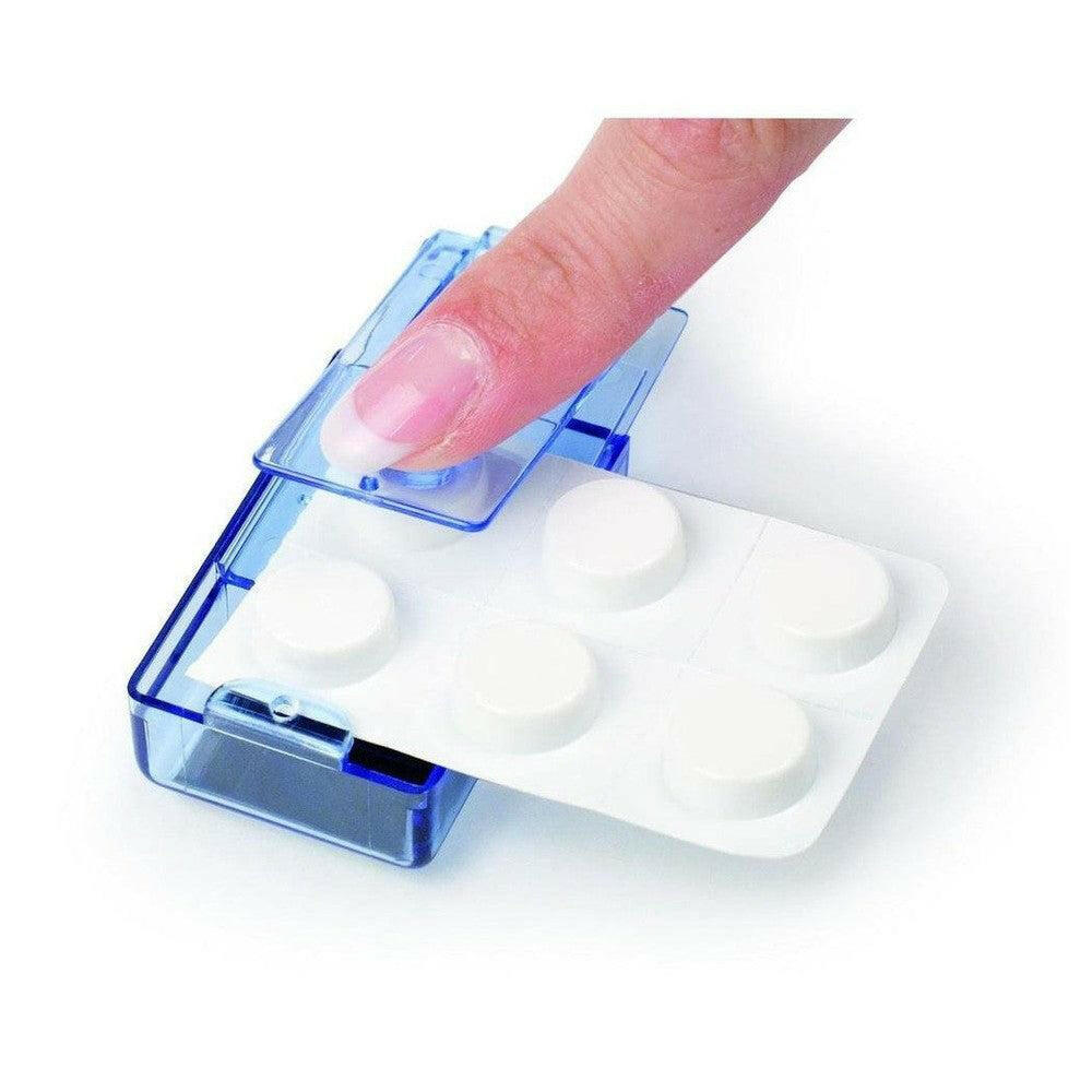 Close-up van blauwe Vitility tabletuitdrukker waarbij een hand een doordrukstrip leeg drukt